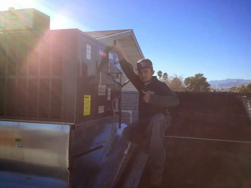 HVAC technician performing HVAC Inspection on a rooftop unit in Glassboro